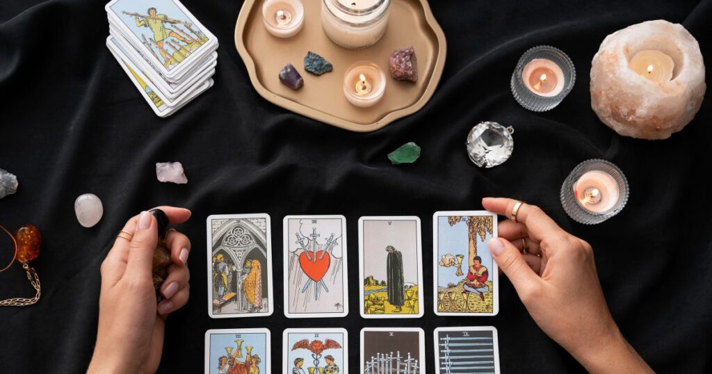 O que é Tarô — cartas espalhadas em mesa com velas e elementos místicos
