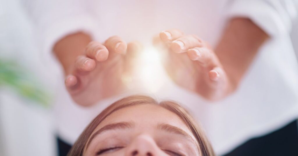 Terapeuta de Reiki realizando sessão profissional em consultório